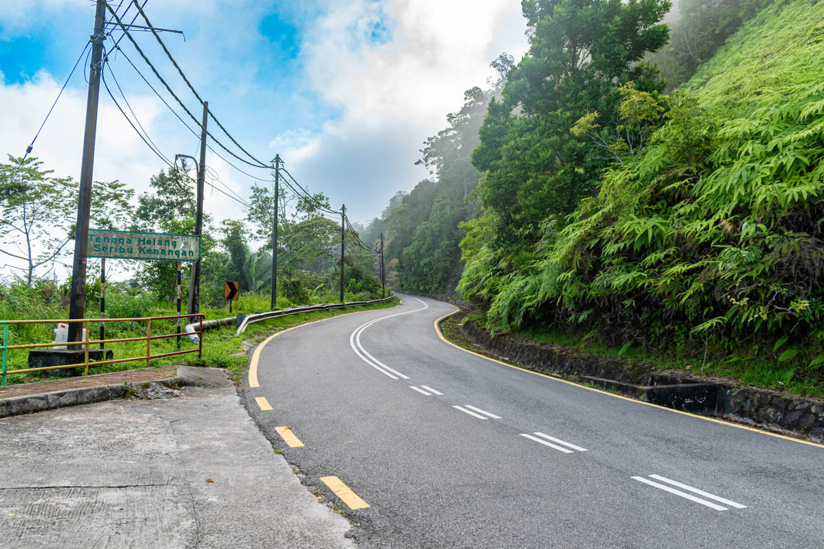 A breathtaking vista of rolling hills awaits you on Gunung Raya's winding road