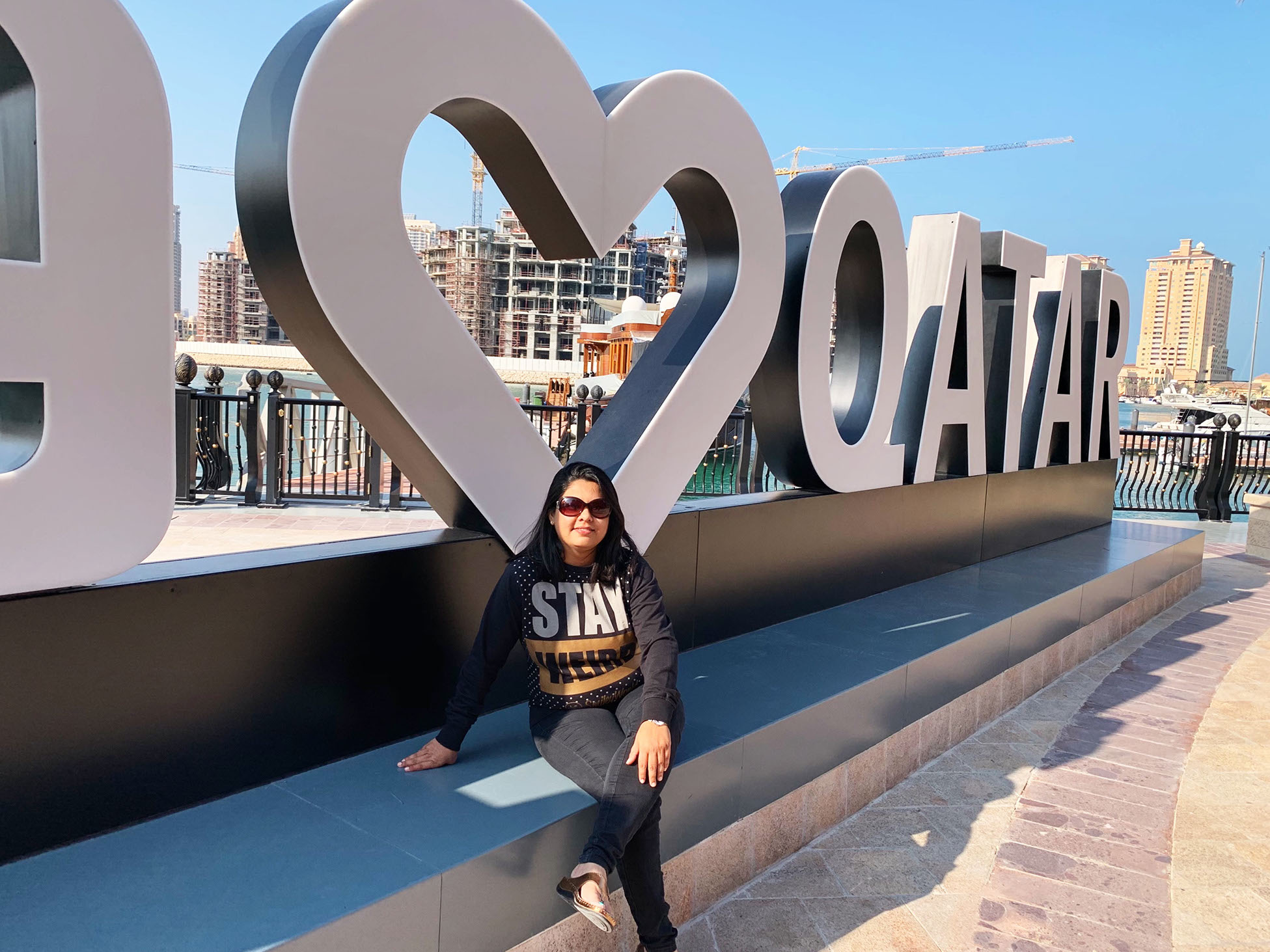 Visitors pose for a picture at the "I Love Qatar" signboard