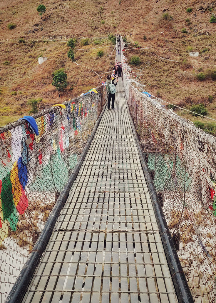 Punakha Suspension Bridge draped in colorful prayer flags is the second longest in Bhutan