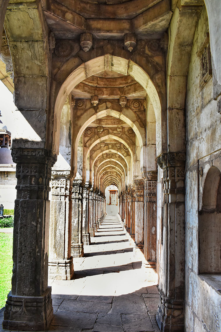 A tranquil corridor surrounds the courtyard of Jami Masjid in Champaner