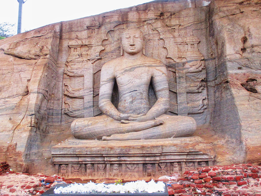 One of the four rock relief statues of sitting Buddha carved on a large granite rock