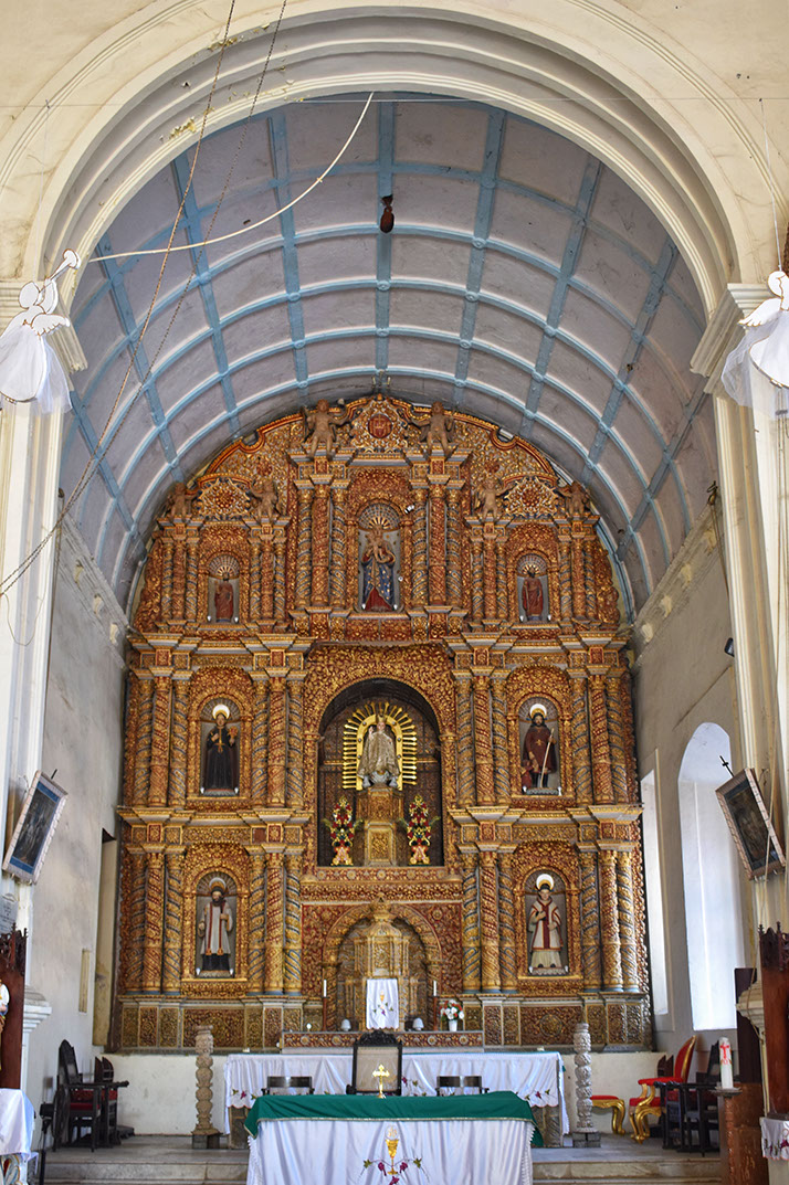 Original Portuguese wood carving art adorns the altar in Daman church