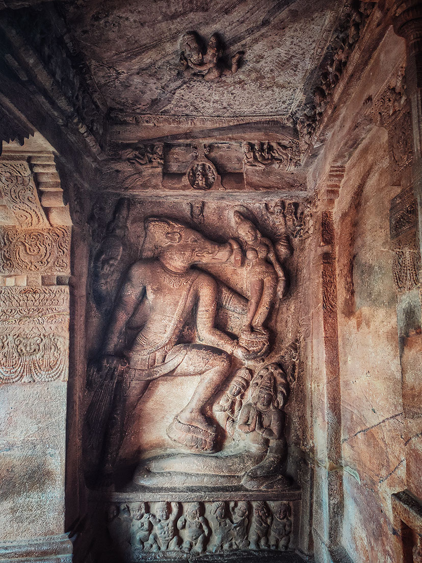 Varaha holding Bhudevi and a flying couple on the ceiling of Badami caves