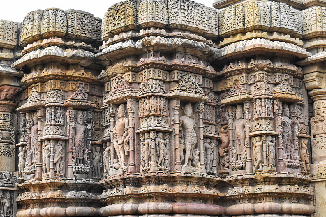 Two adjacent Lord Surya statues at alternate corners of the outer wall of Sun Temple