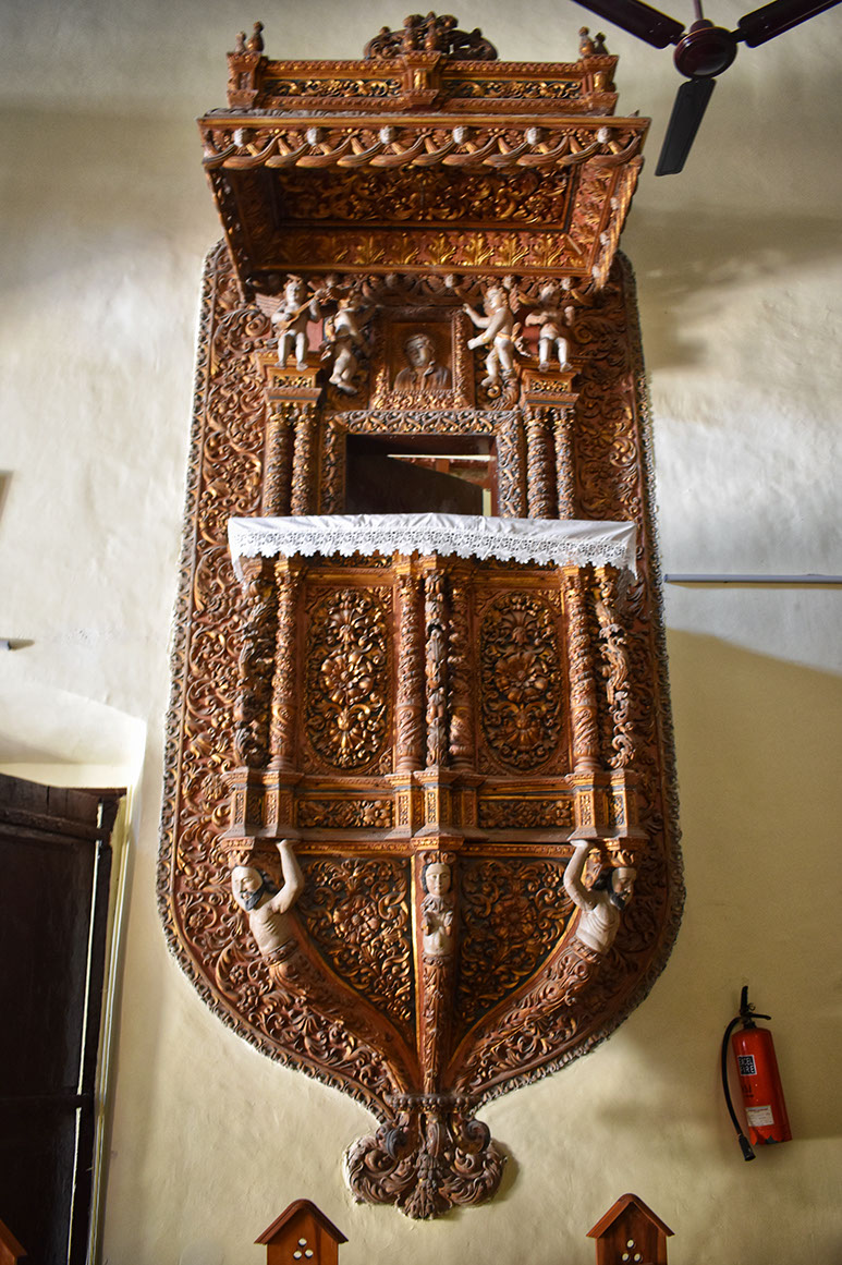 Wooden pulpit with intricate carvings in a church in Daman