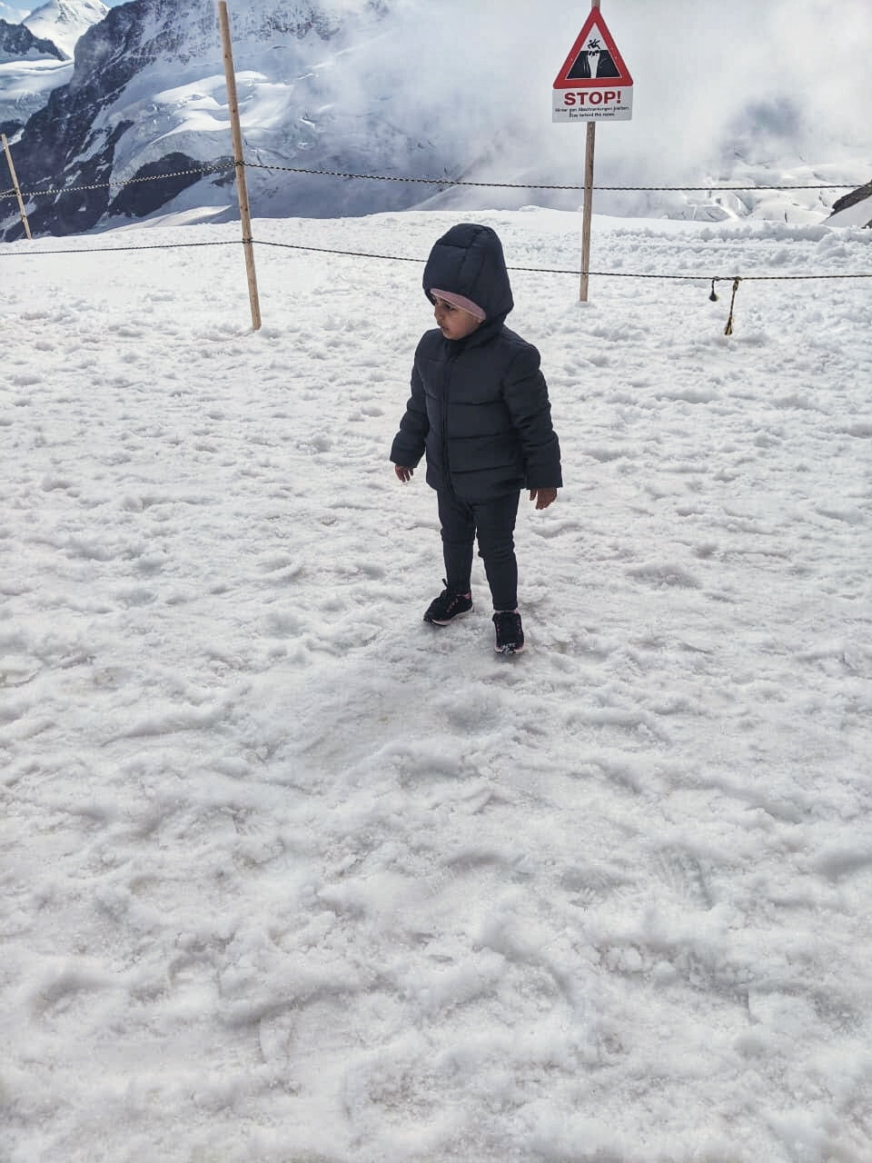 A kid is fascinated by the snow in Mount Titlis