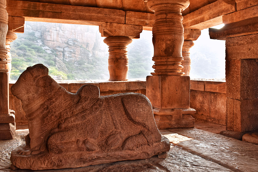 The Sabhamandapa of Bhutanatha temple has rounded pillars and a Nandi