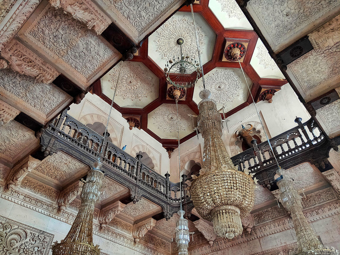 The ceiling of the entrance with fine carvings, sheesham balcony and gorgeous chandeliers