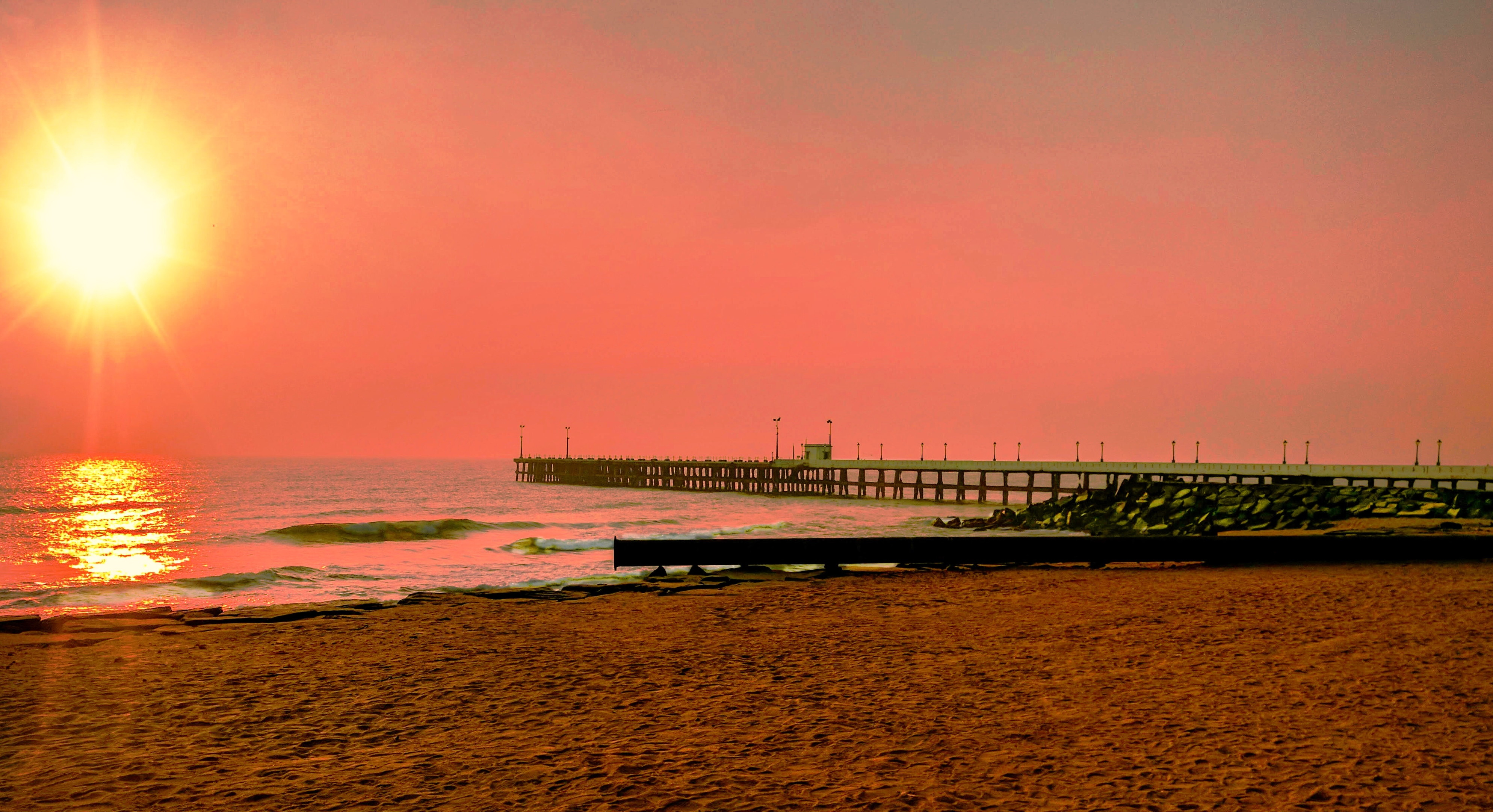 Sunrise at Promenade beach with the view of old pier in Pondicherry
